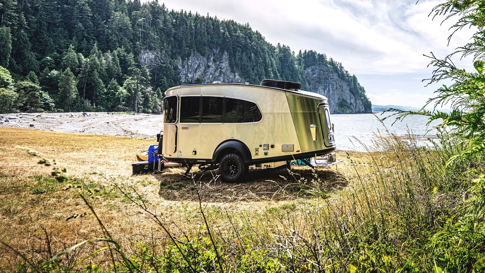 Airstream Basecamp at a lakeside forest campsite