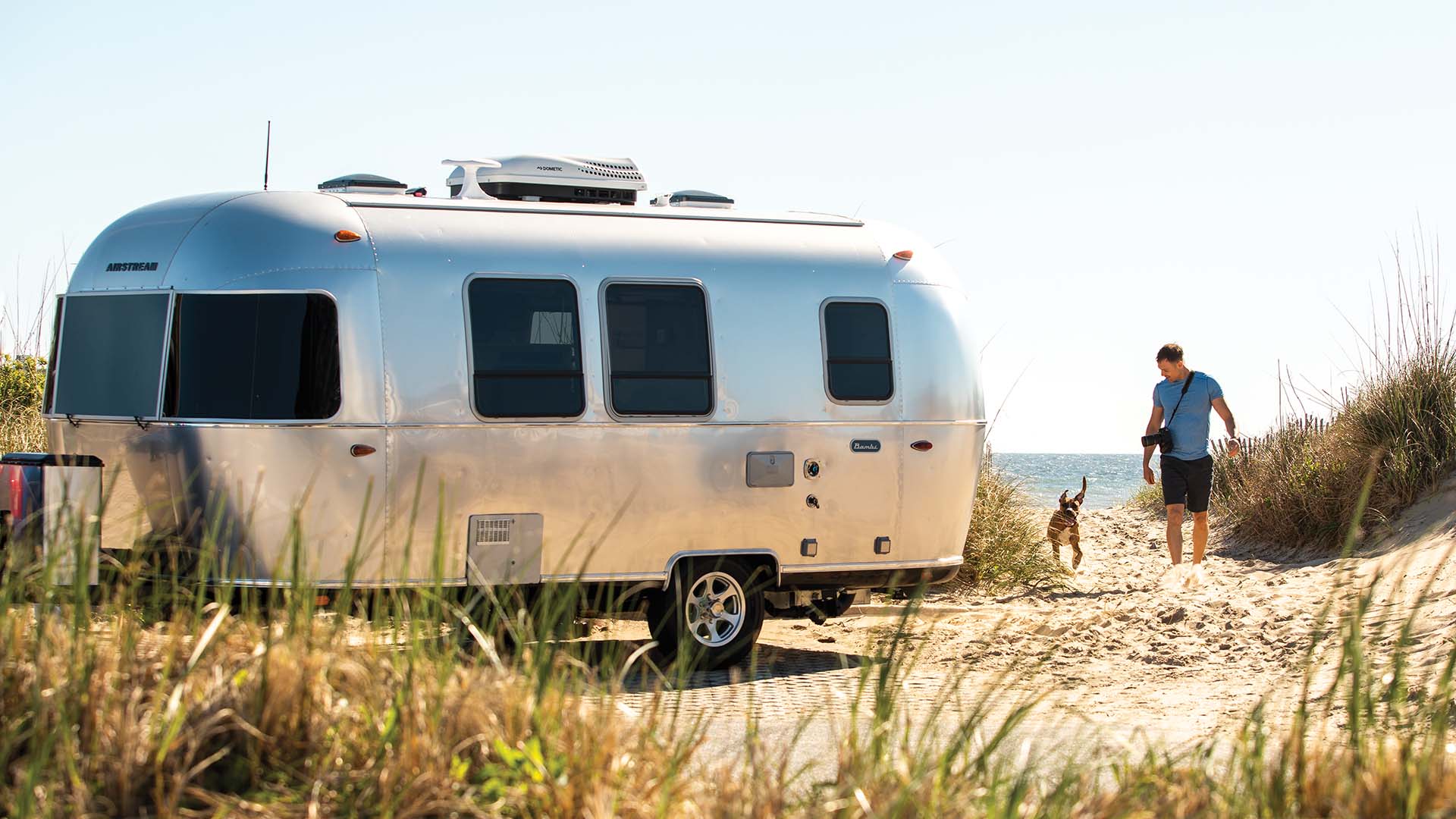 Airstream Bambi with a traveler and dog ready for a weekend outdoors