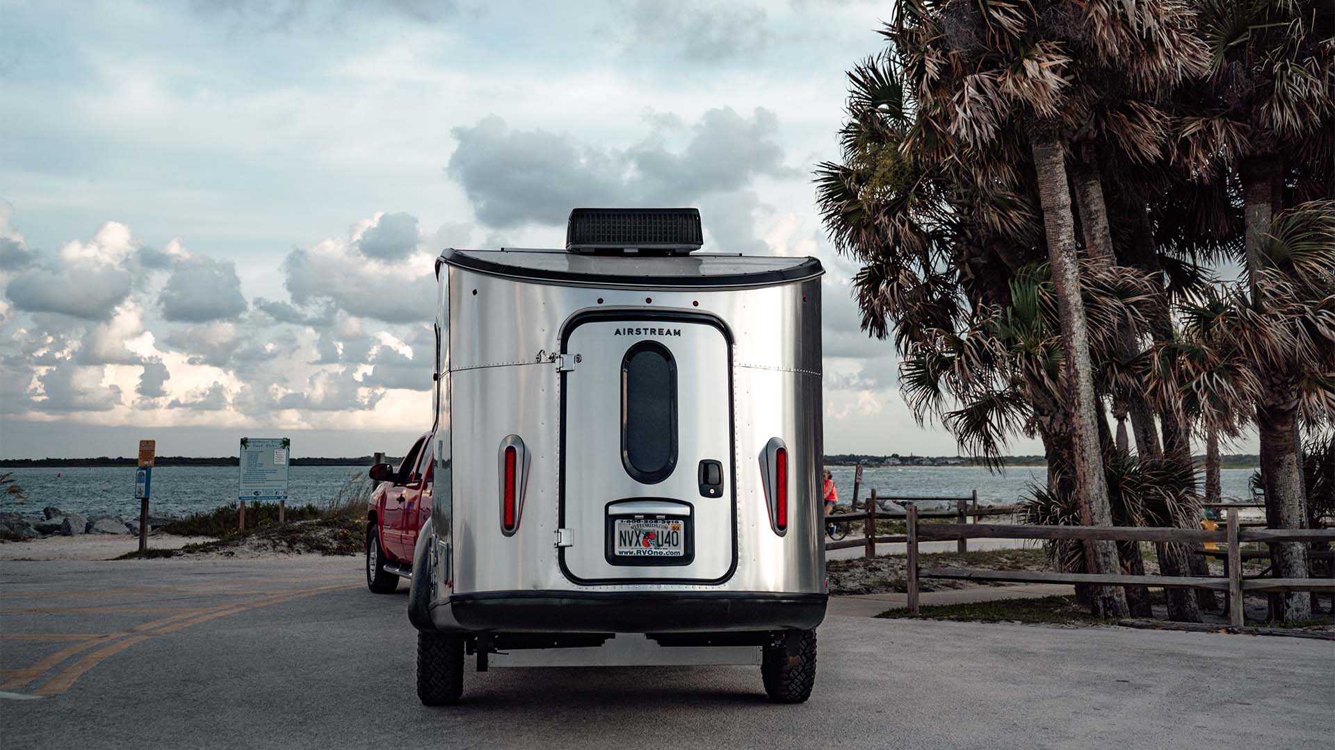 Airstream Basecamp and tow vehicle stopped along a coastal route