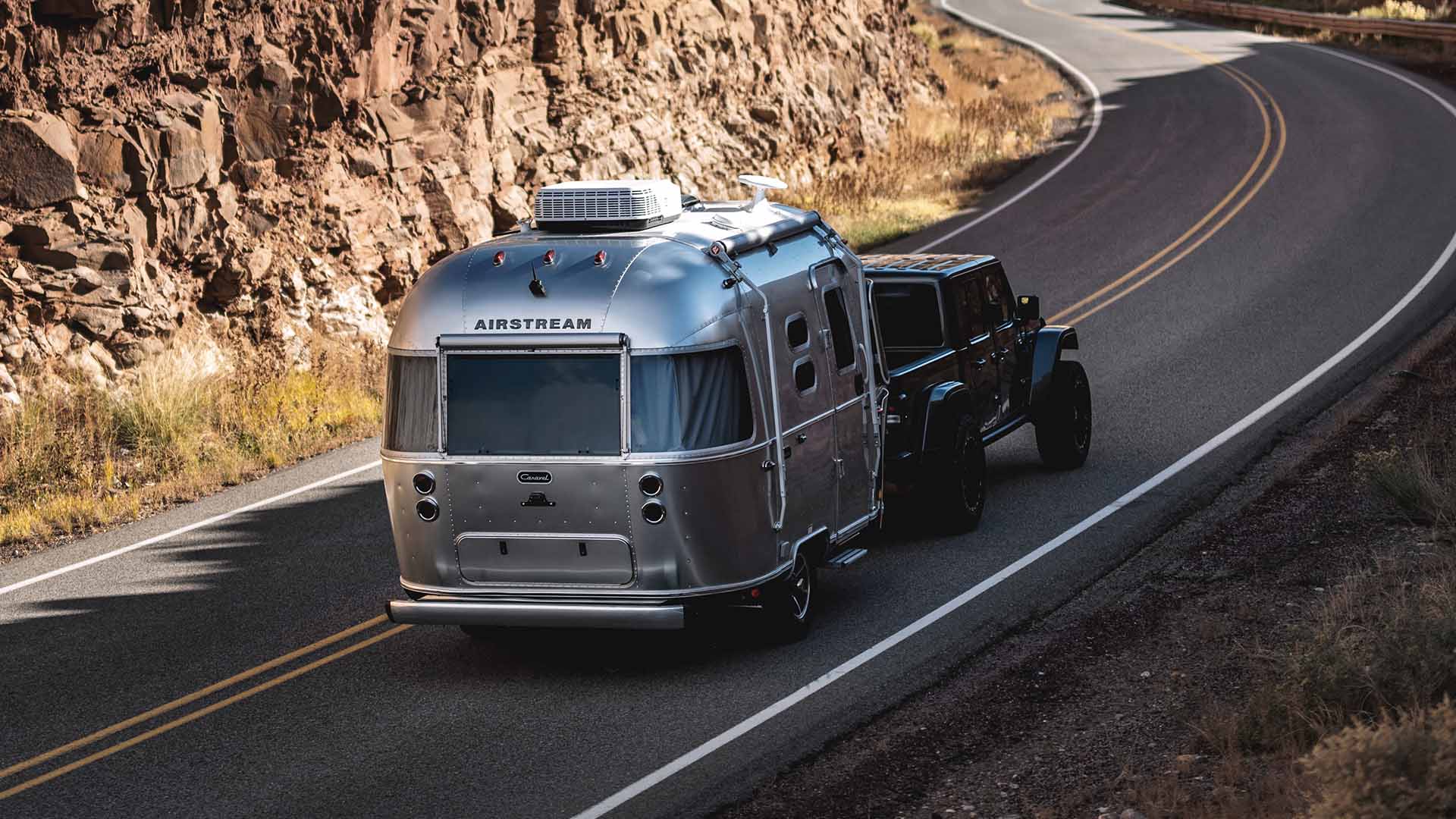 Airstream Caravel being towed along a mountain road