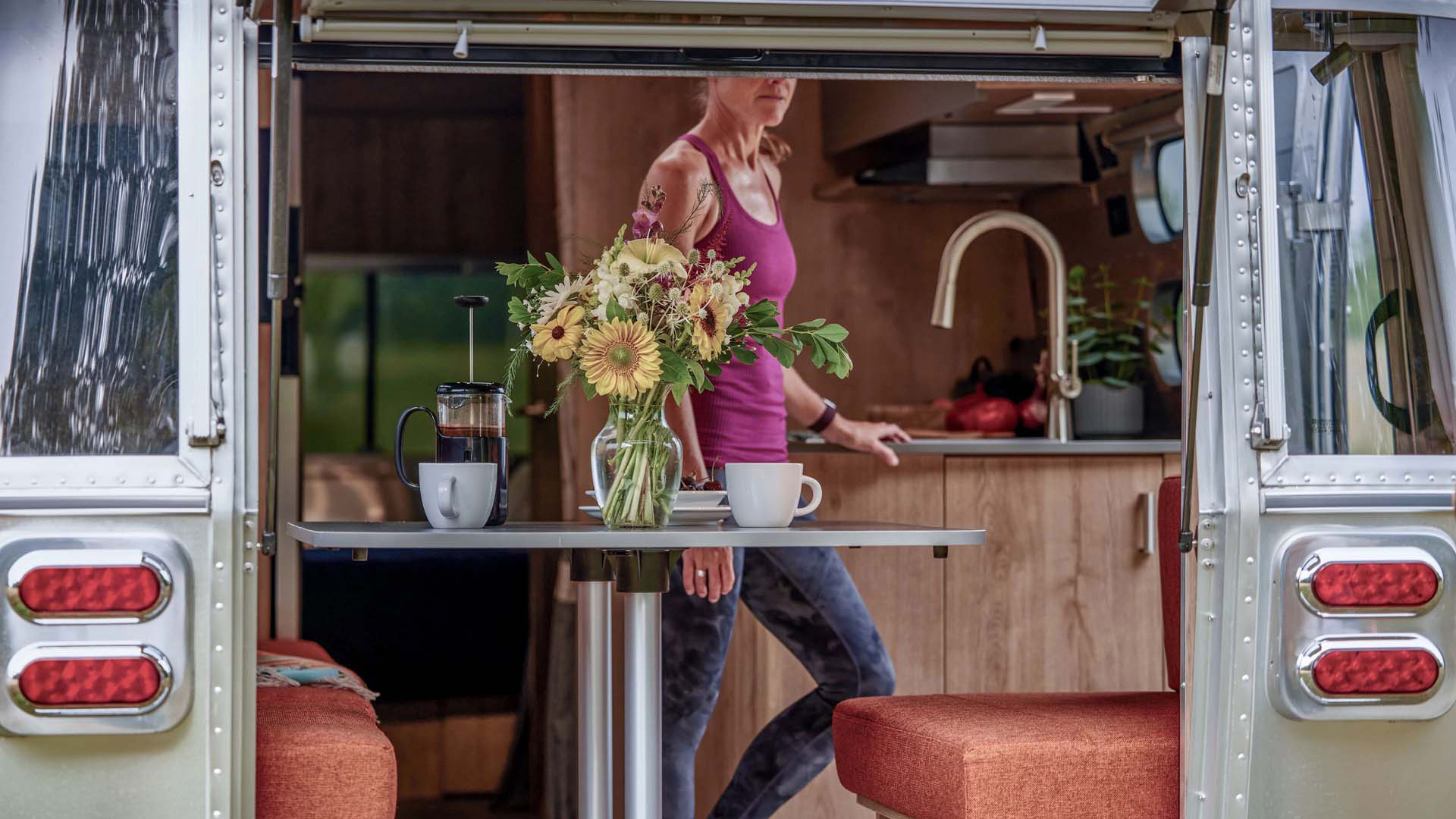 Airstream Trade Wind with its rear hatch open at a wooded campsite